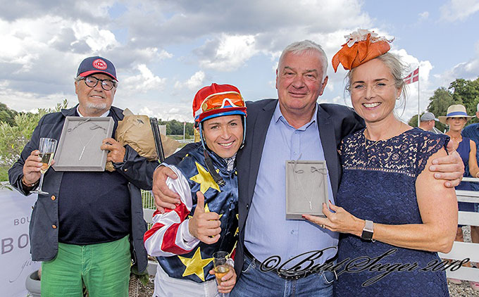 Sponsor for SOC 2018 Bolette Louise Mathiassen overrækker ærespræmier til
	Jes Henneberg fra Odessa Racing Club og Bent Olsen. Jockey Manuel Martinez markerer sejren med tommelen op. Foto Burg Seeger