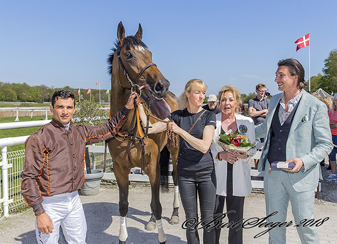 Laila Jeppesen og Marc Elsborg fra Kjeldsbjerggaard ApS
	tager imod Queen Estoril (IRE) og jockey Elione Chaves efter hestens heroiske indsats som klassisk vinder i Dansk Hesteforsikrings Mowerinaløb. Foto Burt Seeger