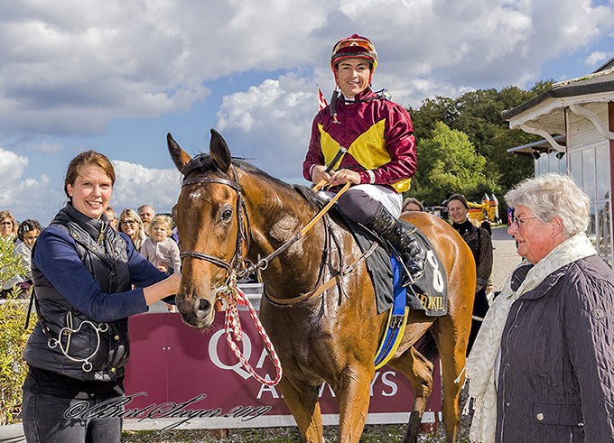 Ejer af New Target, Lone Kaj-Nielsen,
	på vej ind i vindercirklen for at modtage hæder og ære, mens jockey Manuel Martinez og Susanne Springer ser storsmilende til. Foto Burt Seeger