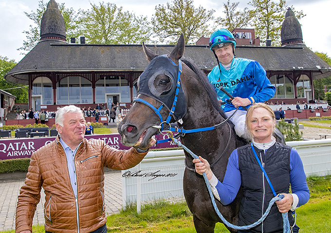Fotograf Burt Seeger har her fanget 4-årige The Maestro, ejet af Ole Torkdahl, med jockey Nicolaj Stott foran vindercirklen efter sejren 22. maj på Klampenborg Galopbane. Bent Olsen ser glad til sammen med Lena Overgaard Hansen.