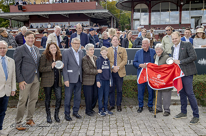 Lone Kaj-Nielsen i vindercirklen efter 2-årige Brigadiers sejr i Dansk Galop Auktionsløb 23. sep. 2023. 
	Stutteri Hjortebo har æren af være opdrætter af Brigadier. Nick Elsass og Henrik Villadsen fra Dansk Galop
	står på hver sin side af familien Hjorth. Foto Burt Seeger