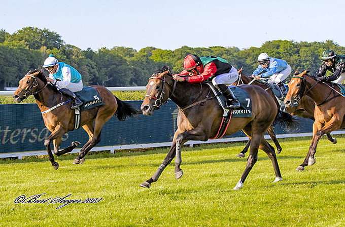 Misszou (GB), ejet af Cowins Springer Racing, i rød, sort og grøn,
	redet af jockey Elione Chaves, på vej mod sejr i 3-års løb, 9. juni 2023. Foto Burt Seeger