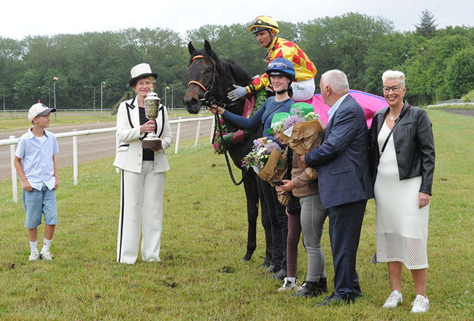Karin Salling alias Mme Fernande overrækker ærespræmie til Bent Olsen og Elione Chaves. Ejer og Oluf I. Jensens Gaard ApS med Frank Hansen modtager også en ærespræmie for sejren i Petit Prix. Foto Ole Hindby